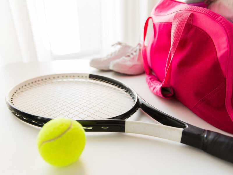sport, fitness, healthy lifestyle and objects concept - close up of tennis racket and balls with female sports bag